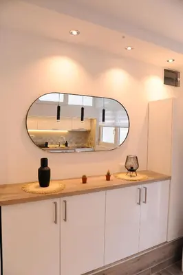 a bathroom with white cabinets and a mirror at 404 Apartment in Belgrade