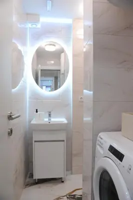 a bathroom with a sink and a washing machine at 404 Apartment in Belgrade