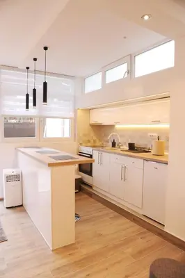 a kitchen with white cabinets and a large island at 404 Apartment in Belgrade