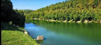 a river with a boat in the middle of it at Šumski raj Lipovica in Lipovica