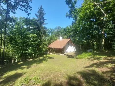 a barn in the middle of a field with trees at Šumski raj Lipovica in Lipovica