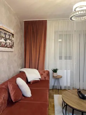 a living room with a brown couch and a table at Stan na dan, Beograd-Žarkovo in Žarkovo