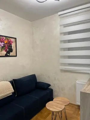 a living room with a blue couch and a table at Stan na dan, Beograd-Žarkovo in Žarkovo