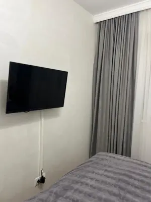a bedroom with a flat screen tv on the wall at Stan na dan, Beograd-Žarkovo in Žarkovo