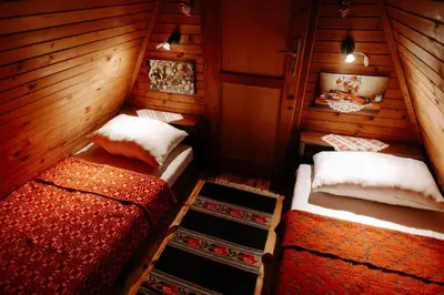 two beds in a room with wooden walls at Čajnički katun-čardak in Grabovac