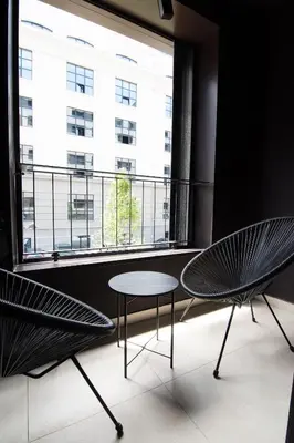 two chairs and a table in front of a window at Apartment - K District Belgrade in Belgrade