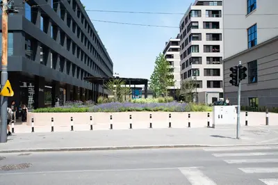 an empty city street with buildings and a flower median at Apartment - K District Belgrade in Belgrade