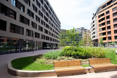 two benches in a park in front of a building at Apartment - K District Belgrade in Belgrade