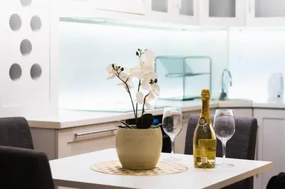 a table with two wine glasses and a vase with flowers at Angelina city LUX apartment with garage in Belgrade