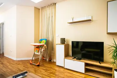 a living room with a flat screen tv and a chair at Angelina city LUX apartment with garage in Belgrade