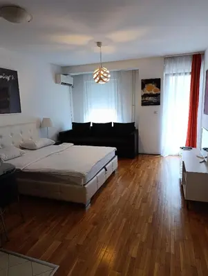 a bedroom with a bed and a living room at Kala in Belgrade