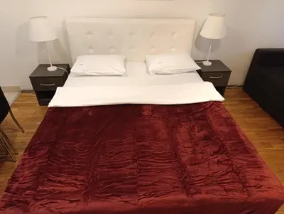 a large bed with a red blanket on it at Kala in Belgrade