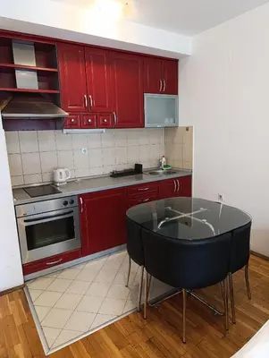 a kitchen with red cabinets and a black table at Kala in Belgrade