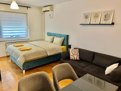 a living room with a bed and a couch at Maison d'Elite in Belgrade
