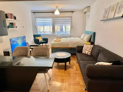 a living room with a couch and a bed at Maison d'Elite in Belgrade
