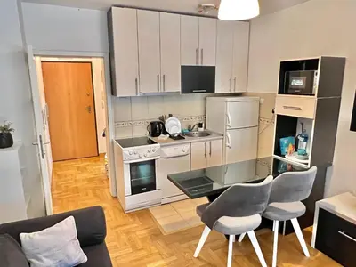 a kitchen with white appliances and a table and chairs at Maison d'Elite in Belgrade