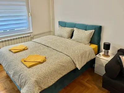 a bedroom with a bed with two yellow towels on it at Maison d'Elite in Belgrade