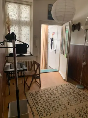 a living room with a table and a door with a umbrella at Apartment Little Oasis TASH in Belgrade