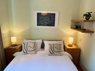 a bedroom with a white bed with pillows and a painting at Lela's Place Vojvode Brane in Belgrade