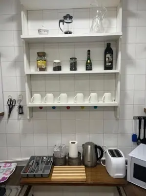 a kitchen with white tiled walls and white shelves at Lela's Place Vojvode Brane in Belgrade