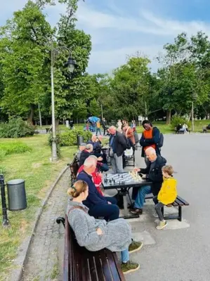a group of people sitting at a table in a park at Lela's Place Vojvode Brane in Belgrade
