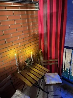 a bench next to a brick wall with two candles at Lela's Place Vojvode Brane in Belgrade