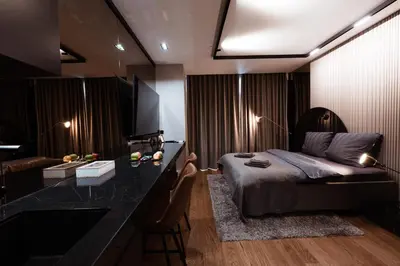 a bedroom with a bed and a desk with a television at inJoy in Sajmište
