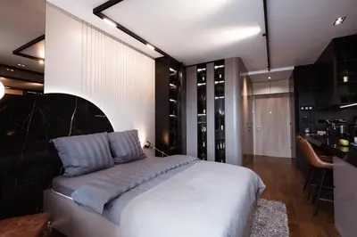 a bedroom with a large white bed and a kitchen at inJoy in Sajmište