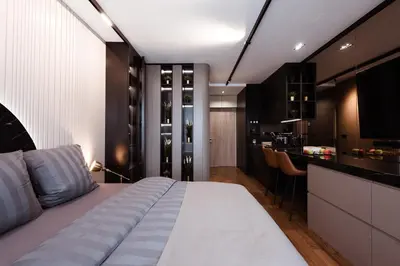 a bedroom with a large white bed and a kitchen at inJoy in Sajmište