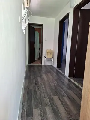 a room with a wooden floor and some doors at Kuća za odmor Sara in Čortanovci
