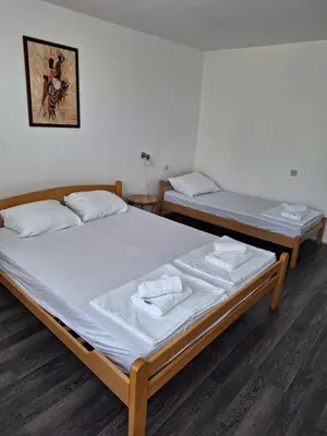 two beds in a room with white sheets at Kuća za odmor Sara in Čortanovci