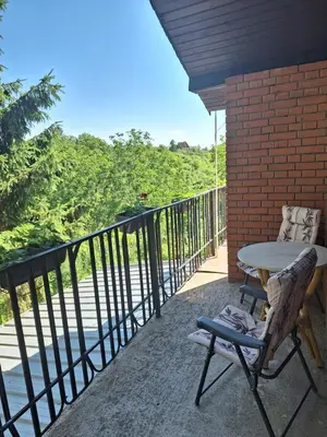 a patio with a table and a chair on a balcony at Kuća za odmor Sara in Čortanovci