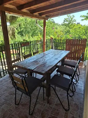a wooden table and chairs on a patio at Kuća za odmor Sara in Čortanovci