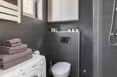 a bathroom with a toilet and a shower and towels at 3 Steps from Center in Belgrade