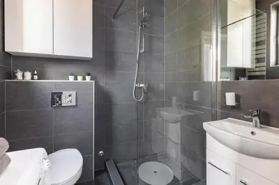 a bathroom with a shower and a toilet and a sink at 3 Steps from Center in Belgrade