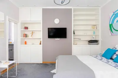 a bedroom with a bed and a tv on a wall at 3 Steps from Center in Belgrade