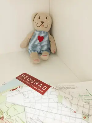 a stuffed teddy bear sitting on top of a map at 3 Steps from Center in Belgrade
