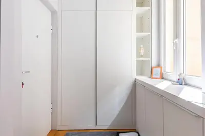 a white bathroom with a sink and a window at 3 Steps from Center in Belgrade