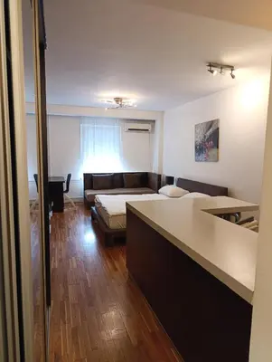 a living room with a bed and a couch at Iris Slavija in Sajmište