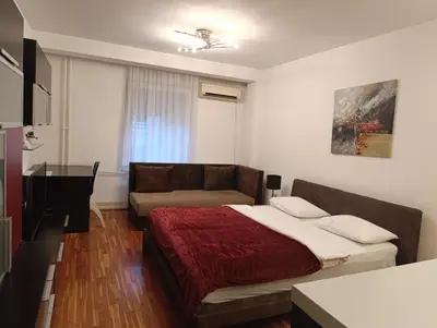 a bedroom with a bed and a couch at Iris Slavija in Sajmište