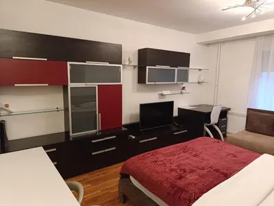 a bedroom with a bed and a desk with a computer at Iris Slavija in Sajmište