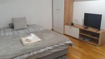 a bedroom with a bed with a tv and a table at Ada mall-Beograd 2 bedroom in Čukarica