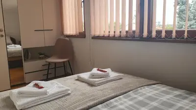 a bedroom with towels on a bed with a chair at Ada mall-Beograd 2 bedroom in Čukarica
