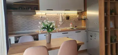a kitchen with a table with a vase of flowers on it at Ada mall-Beograd 2 bedroom in Čukarica