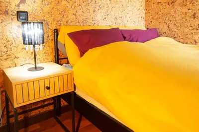 a yellow bed with a lamp on a night stand at Goldy in Belgrade
