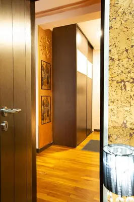 a hallway with a door leading into a room with wooden floors at Goldy in Belgrade