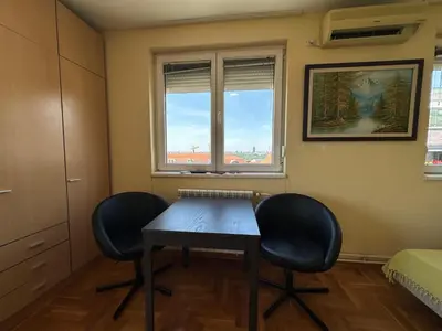 a room with two chairs and a table and a window at apartman Ada mall in Čukarica