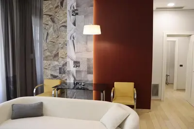 a living room with a white couch and yellow chairs at Zepter Hotel Belgrade, member of Zepter Hotels in Belgrade