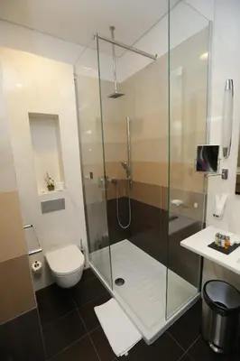 a bathroom with a shower and a toilet and a sink at Zepter Hotel Belgrade, member of Zepter Hotels in Belgrade