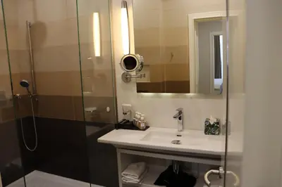 a bathroom with a shower and a sink and a mirror at Zepter Hotel Belgrade, member of Zepter Hotels in Belgrade